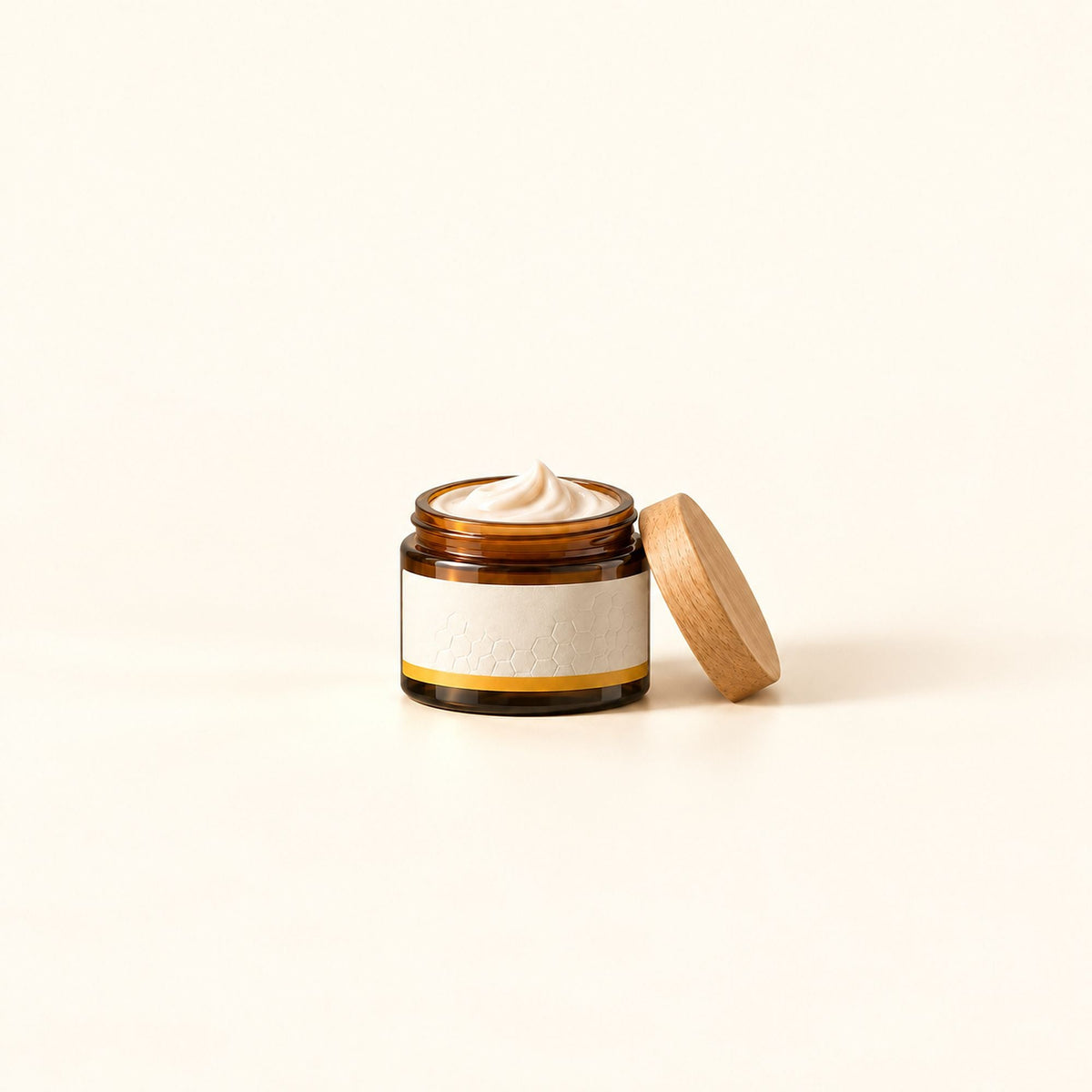Pot de crème ouvert en verre ambré sur fond crème